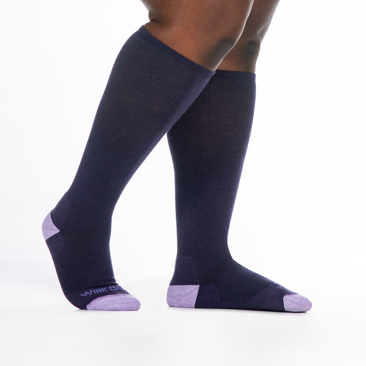 9517 blackberry knee high sock with lavender heel/toe/logo, shown from the side with back foot lifted