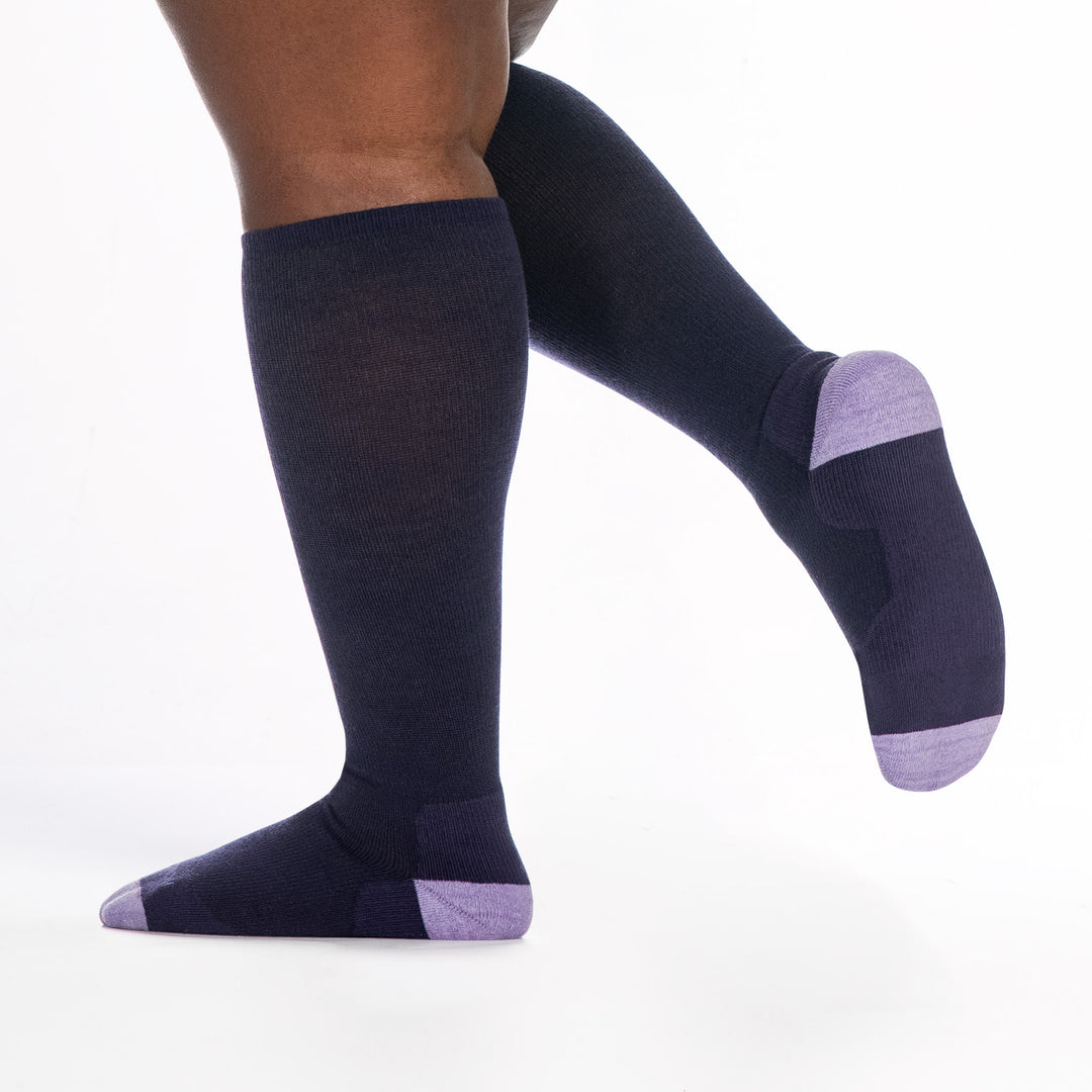 9517 blackberry knee high sock with lavender heel/toe/logo, shown from the side and back with back foot raised off the ground