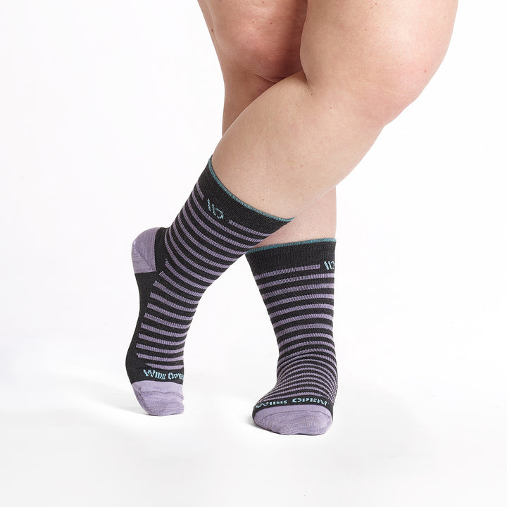 9518 Charcoal crew sock with purple stripes, teal heel/toe, and light blue cuff trim, shown from front with legs crossed.
