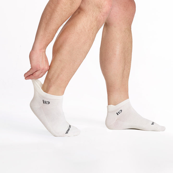 model stretching the back of the left foot sock wearing the 9013 lightweight ankle sock in white