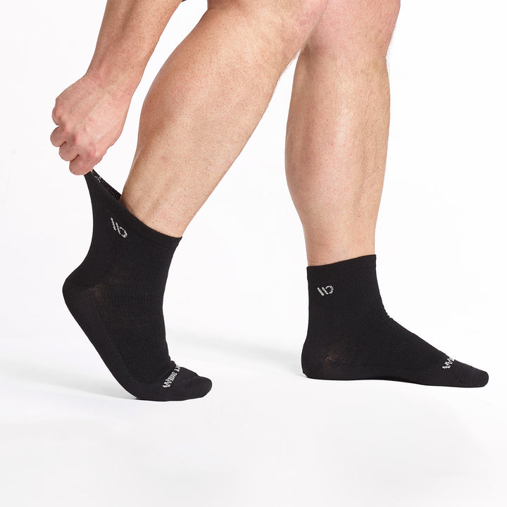 model stretching the back sock on the 9014 lightweight quarter sock in black 