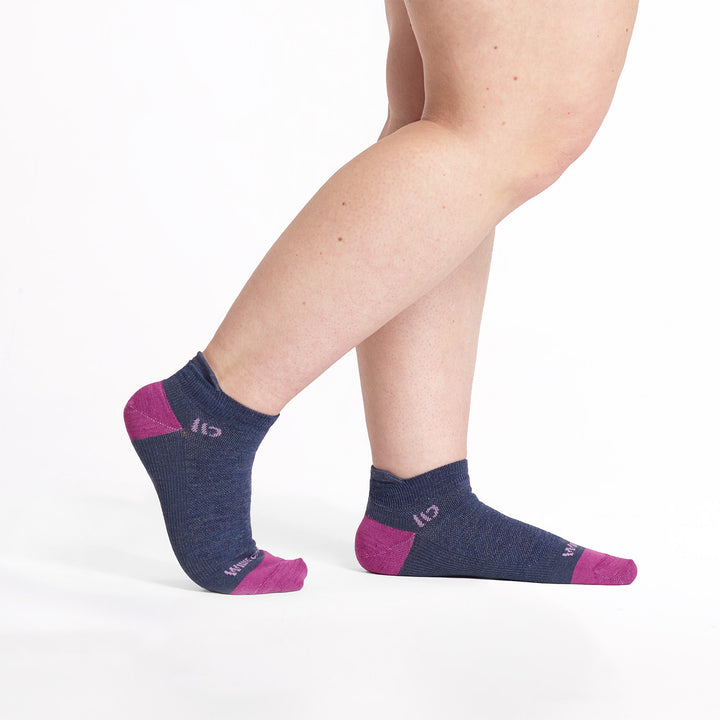 Models feet pointed to the right with the back foot lifted wearing the 9514 lightweight ankle in denim