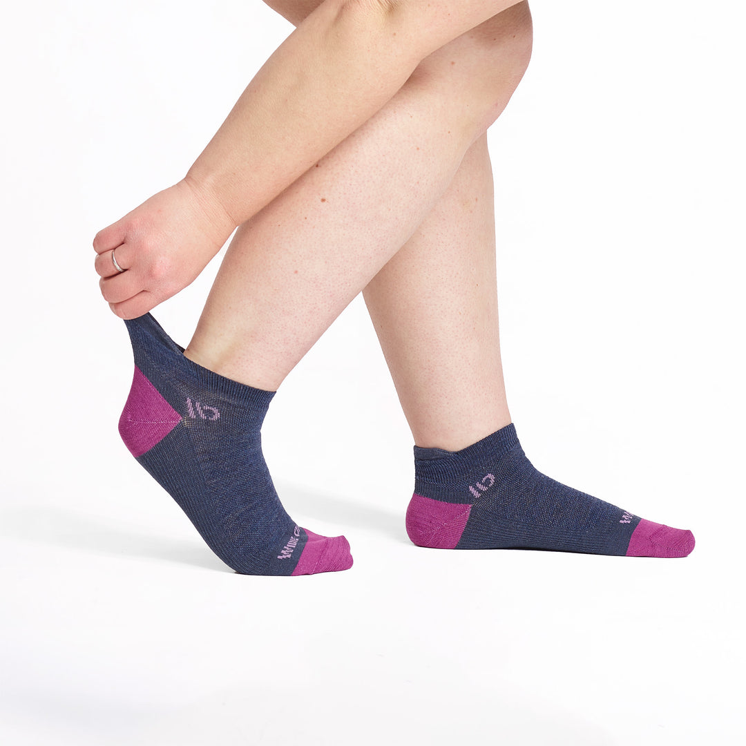 Model stretching back sock wearing the 9514 lightweight ankle sock in denim