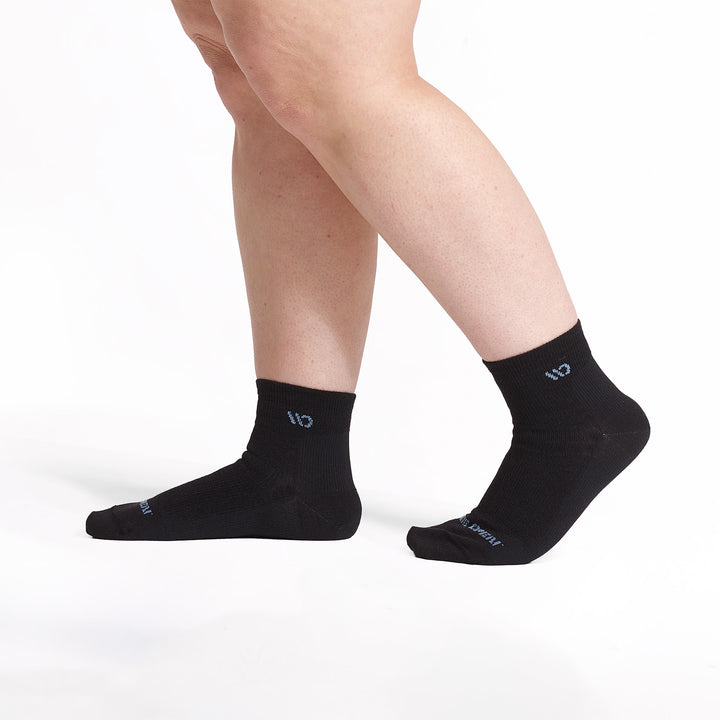 models feet walking to the left wearing the 9515 lightweight quarter sock in black 