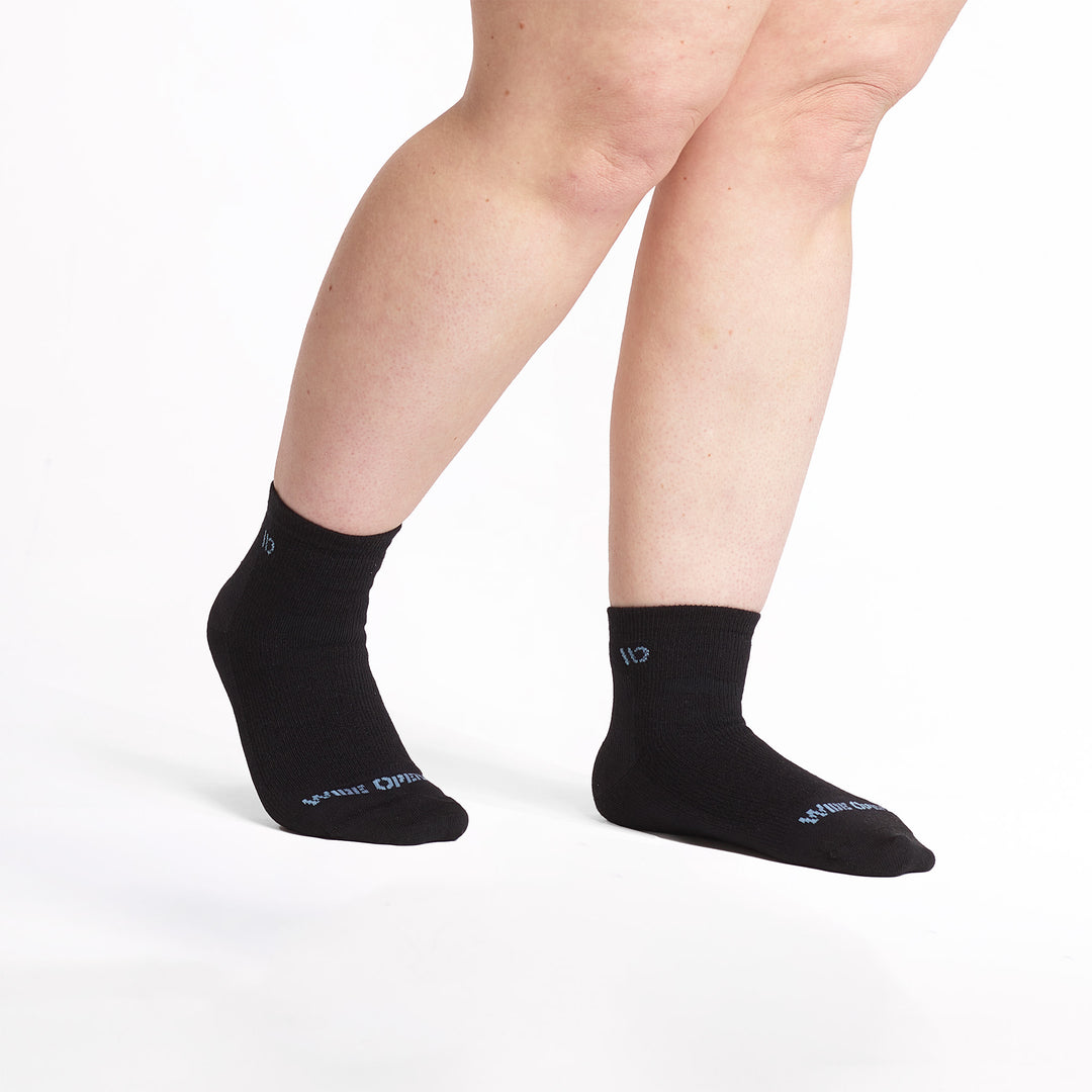 Model feet pointed to the right wearing the 9515 Lightweight quarter sock in black