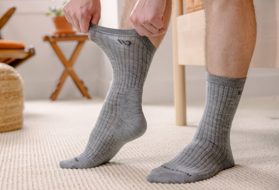 Model demonstrating the stretch and width of gray Wide Open Socks designed for wide feet.