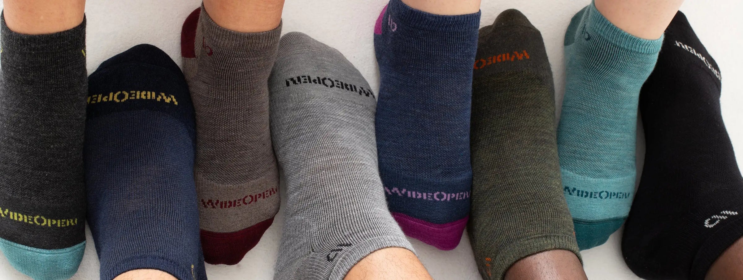 Row of feet modeling Wide Open wide socks in assorted colors for wide feet.